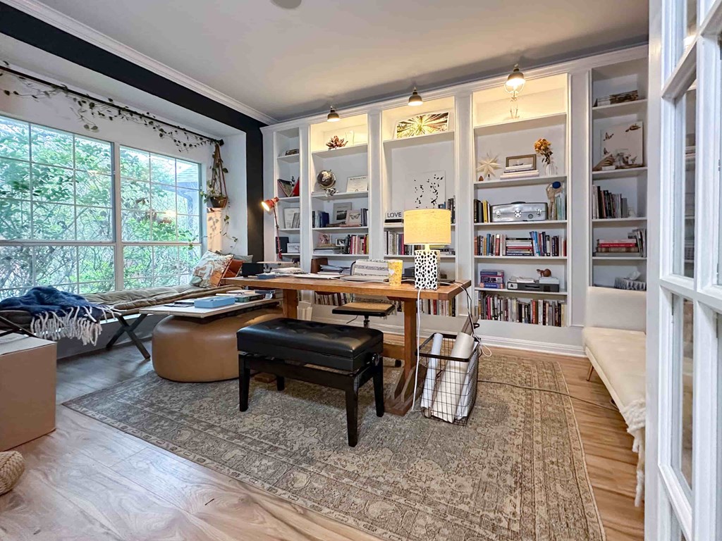 A room with a desk, chair, and bookshelves.