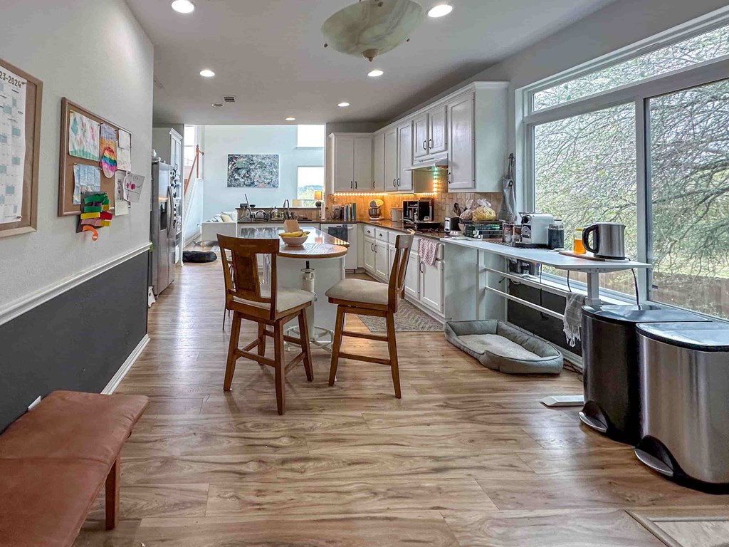A kitchen with wooden floors and a large window.