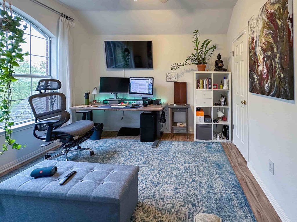 A room with a desk, chair, and computer setup.