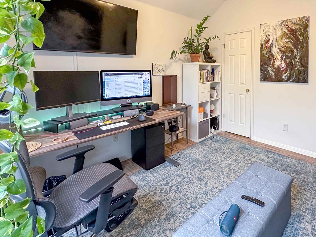 A home office with a desk, chair, and computer setup.