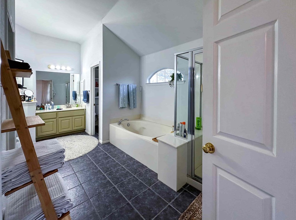 A bathroom with a white tub and a wooden ladder.