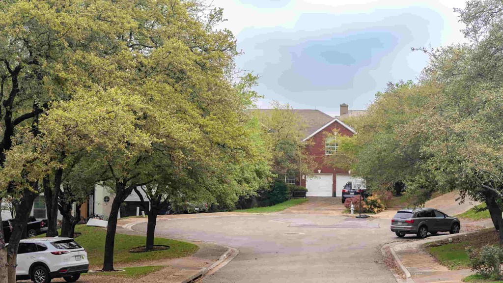 A residential street with cars parked on the side.