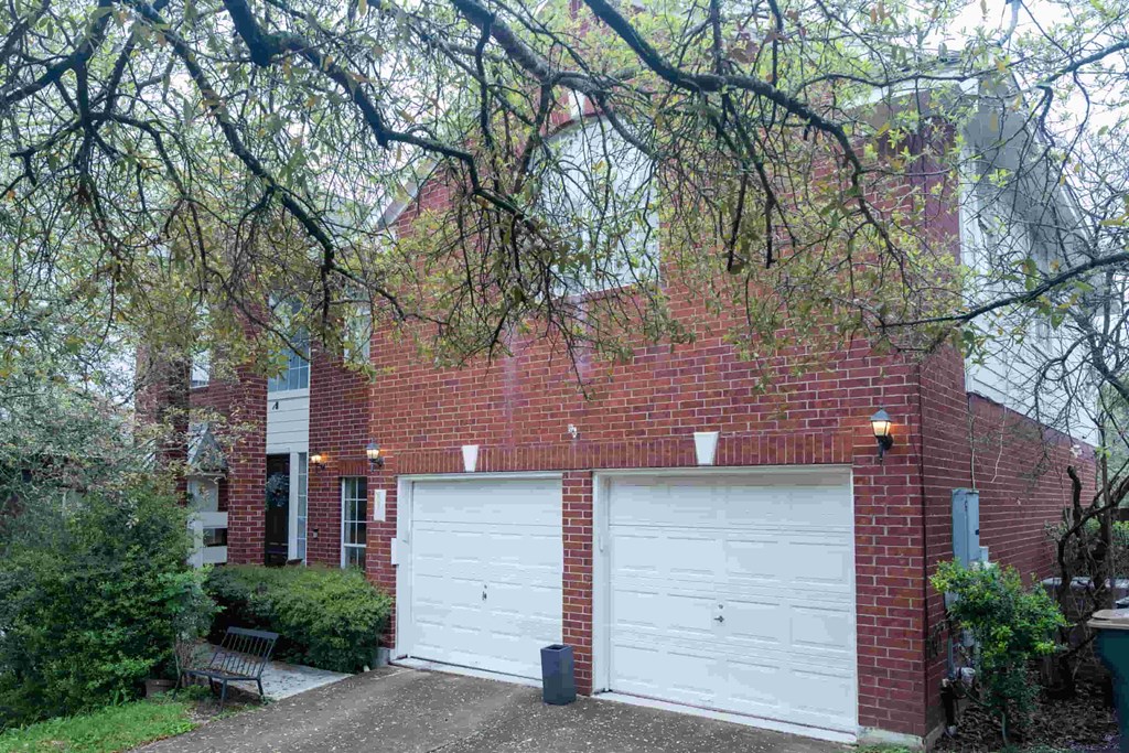 A red brick house with a white garage door.