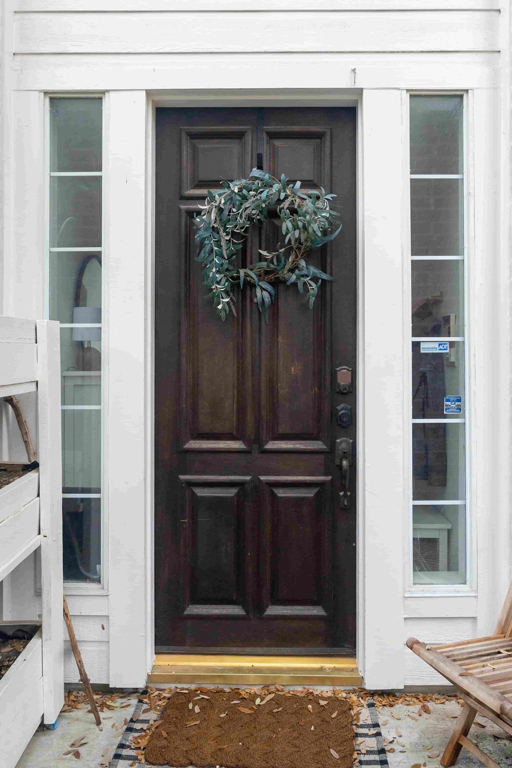 A brown door with a wreath on it.