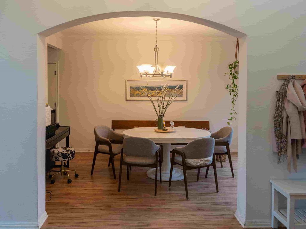 A dining room with a round table and chairs.