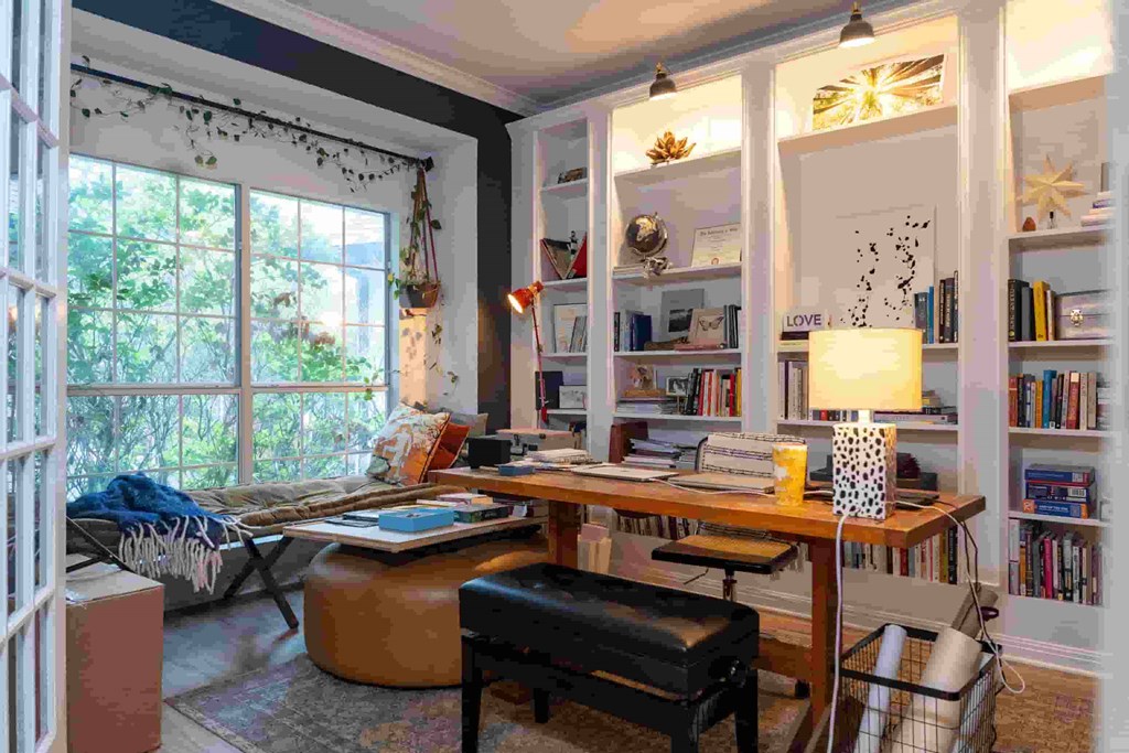 A room with a desk, chair, and bookshelf.