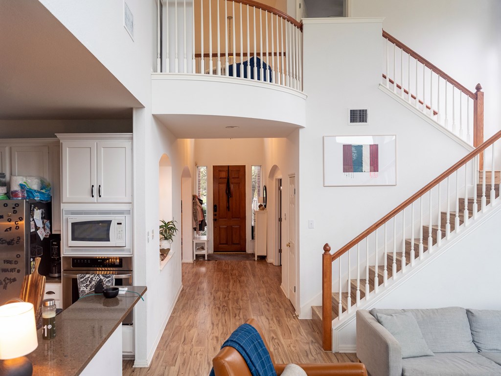 A living room with a couch and a staircase.