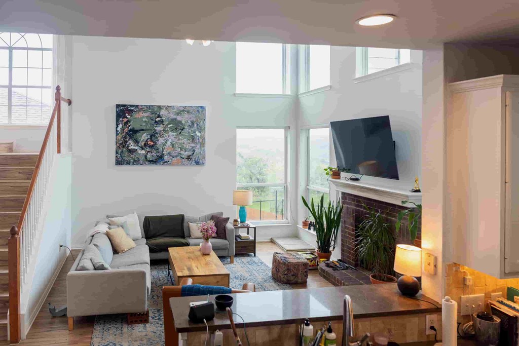 A living room with a couch, coffee table, and a painting on the wall.