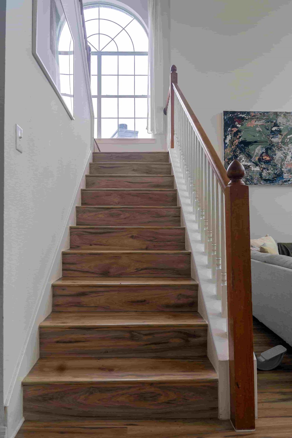 A staircase with wooden steps and a white railing.
