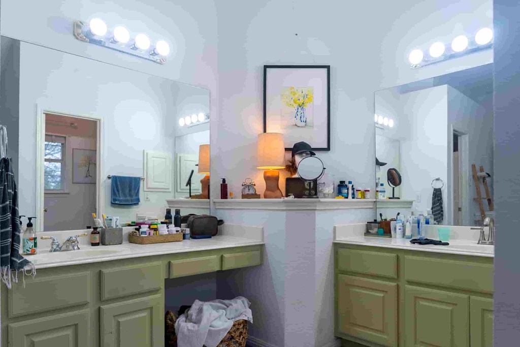 A bathroom with two sinks and a mirror above the counter.