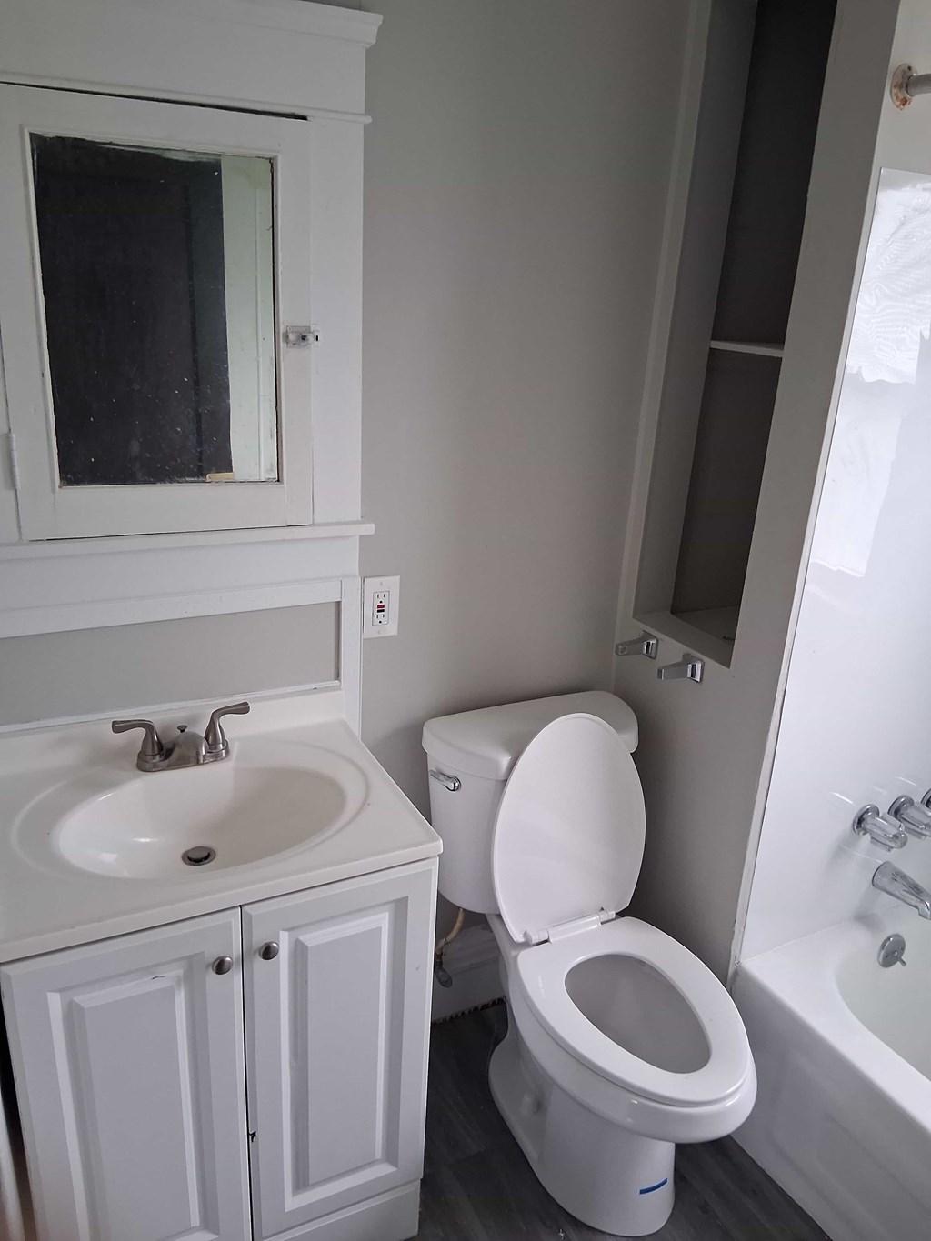 A white toilet sits next to a sink in a bathroom.