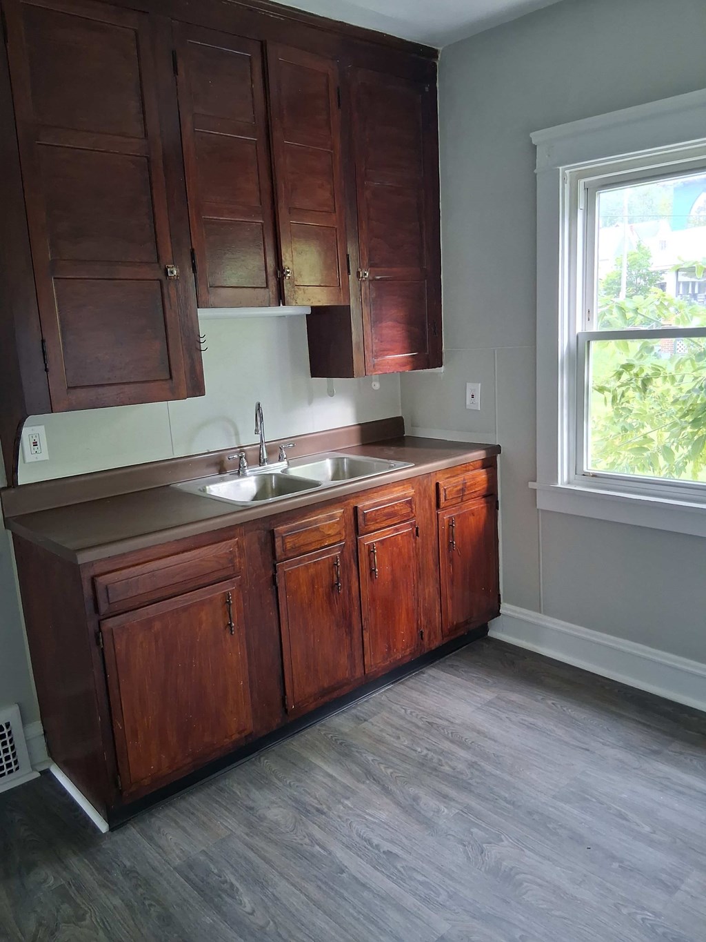 A kitchen with wooden cabinets and a window.