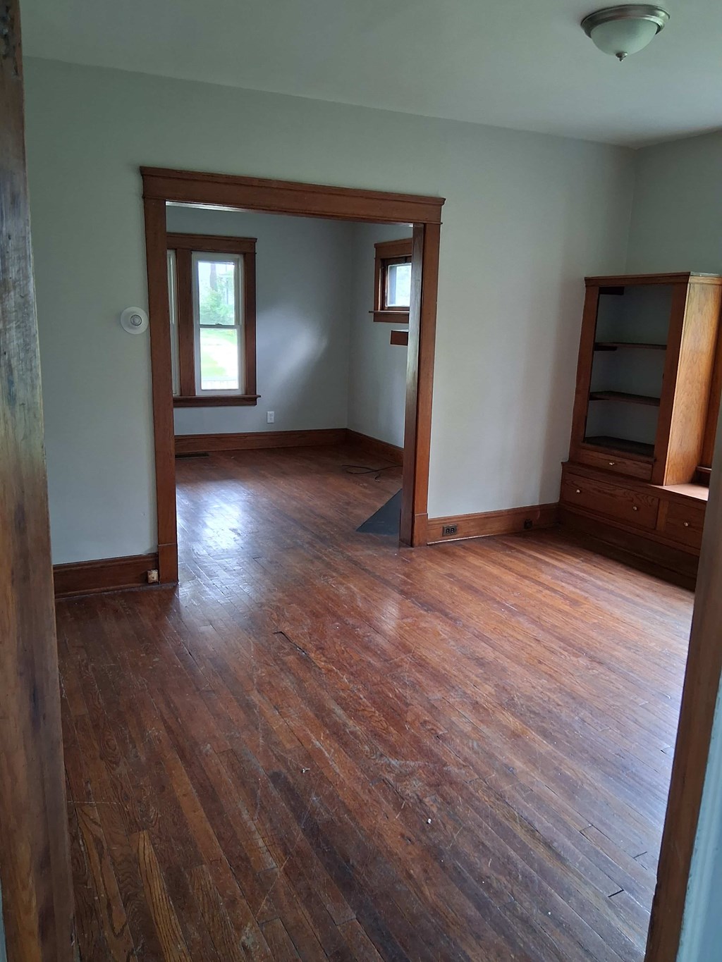 A room with wooden floors and a large mirror on the wall.