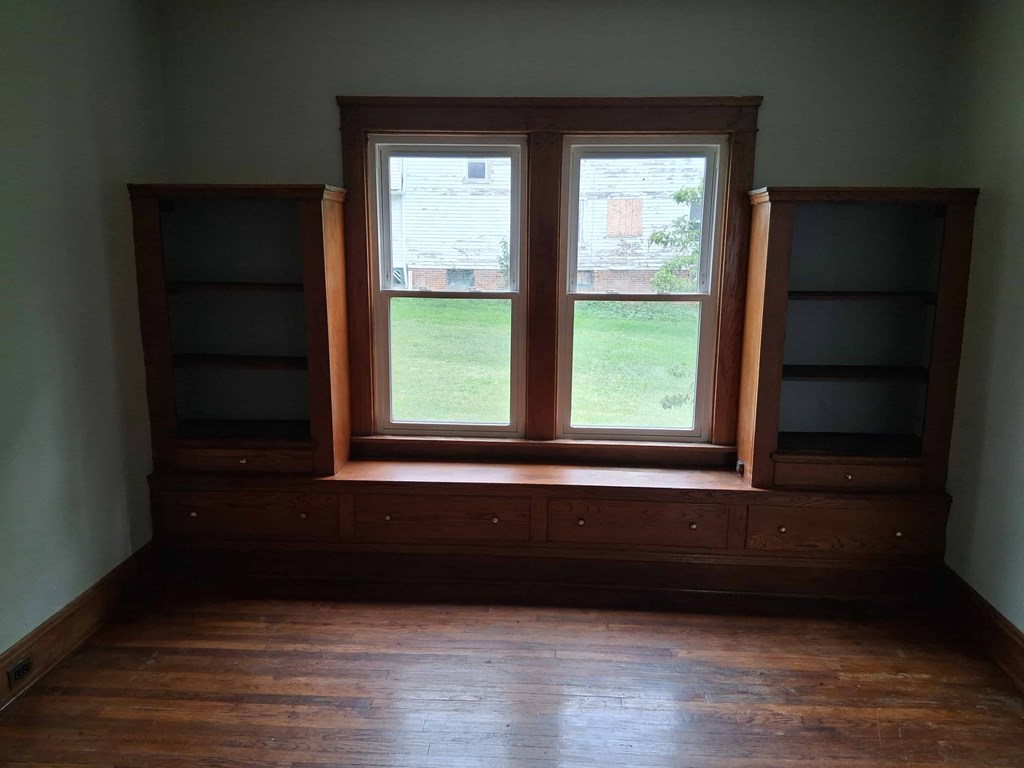 A room with a window and wooden floors.