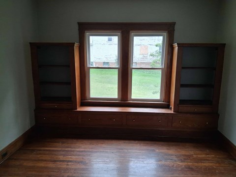 A room with a window and wooden floors.