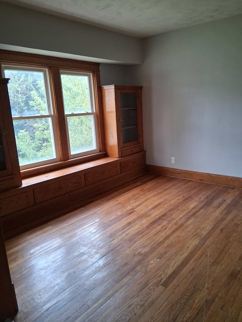 A room with wood flooring and a window.
