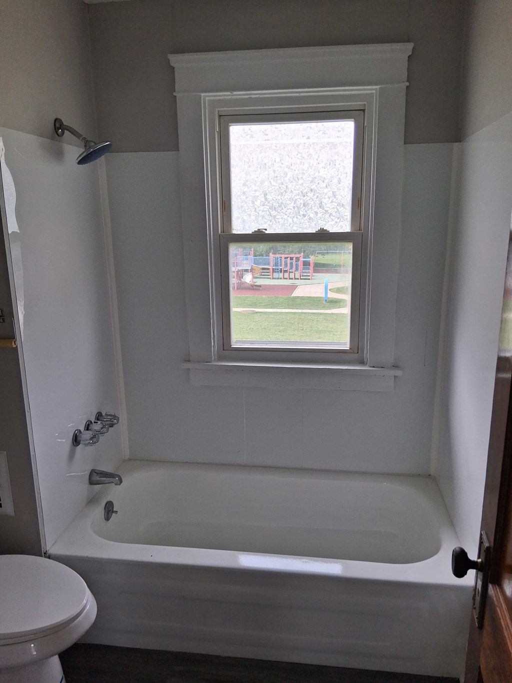 A white bathroom with a tub and toilet.