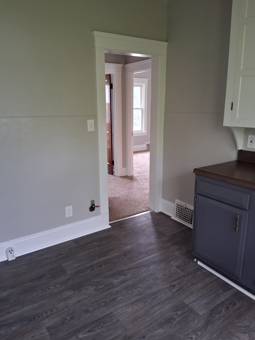 A room with a wooden floor and a white wall.