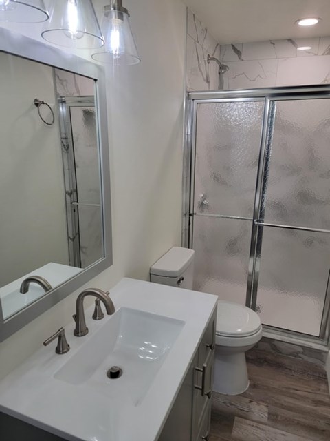 A white sink with a silver faucet is in front of a mirror in a bathroom.