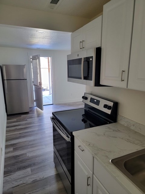 A kitchen with a stove top oven and a microwave above it.