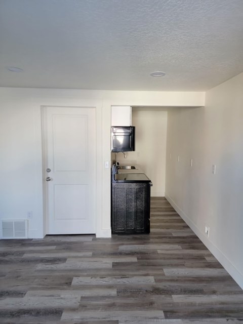 A room with a white door and a wooden cabinet.