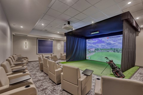 A room with a large screen and chairs.