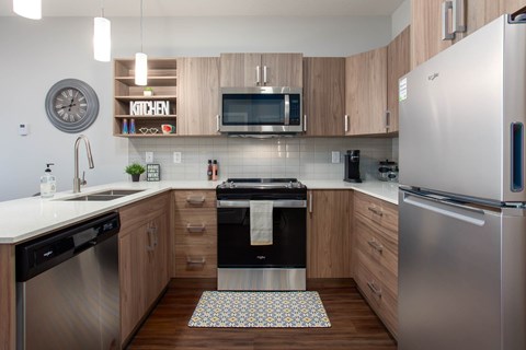 A modern kitchen with a stainless steel refrigerator and wooden cabinets.