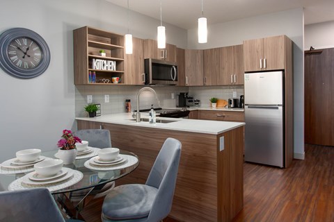 A modern kitchen with a glass table and chairs.