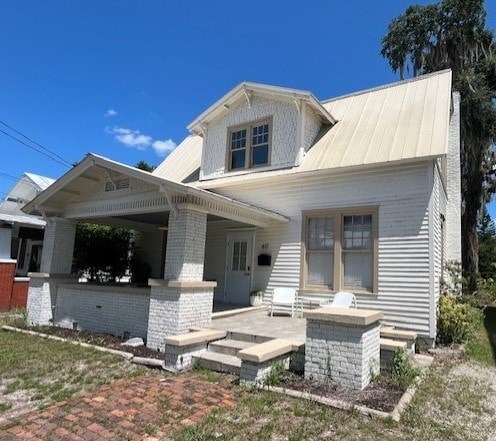 A white house with a porch and a covered entrance.