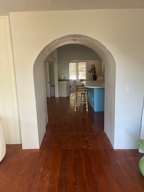 A hallway with a wooden floor and white walls.