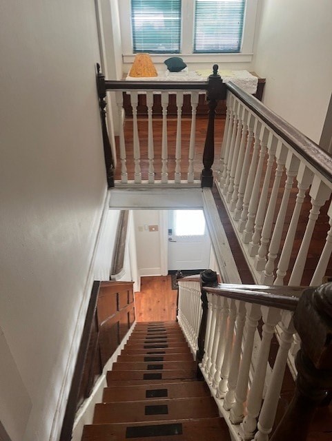 A staircase with a white railing and wooden steps leading to a bedroom.