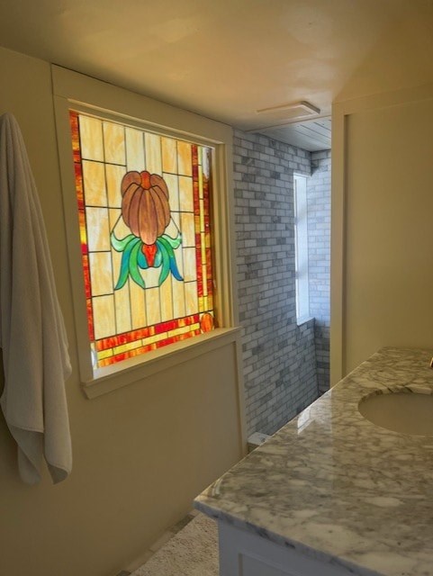 A bathroom with a stained glass window and marble countertop.
