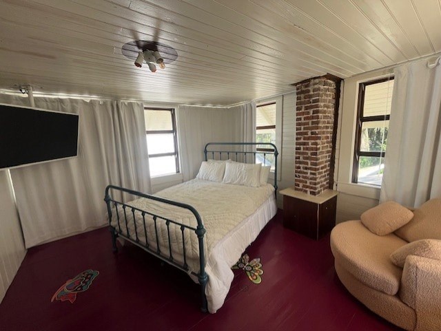 A bedroom with a bed, chair, and a ceiling fan.