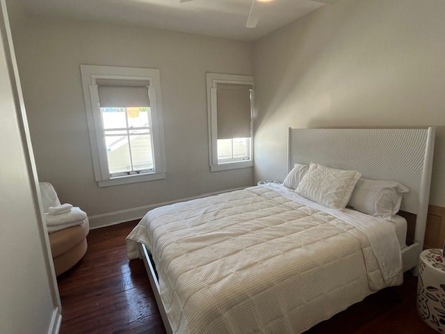 A white bed with a white headboard and pillows in a room with a window.