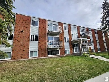 A red brick apartment building with white trim and balconies.