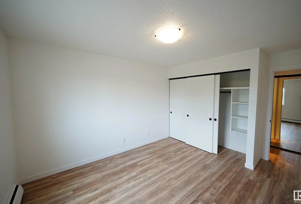 A room with a white door and a light on the ceiling.