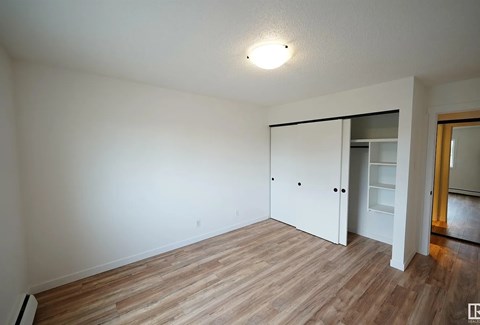 A room with a white door and a light on the ceiling.