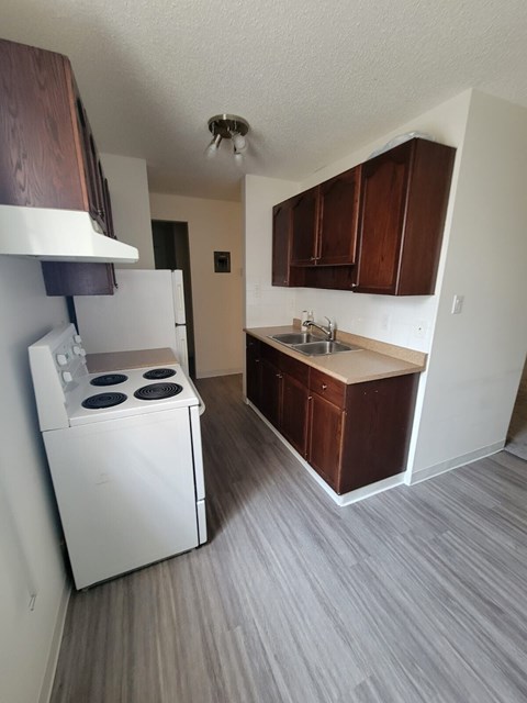 A small kitchen with a white fridge and a white stove.