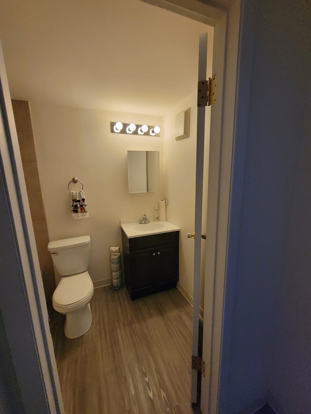 A bathroom with a toilet, sink, and mirror.