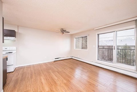 A room with a ceiling fan and a window with blinds.