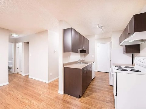 A kitchen with white appliances and brown cabinets.