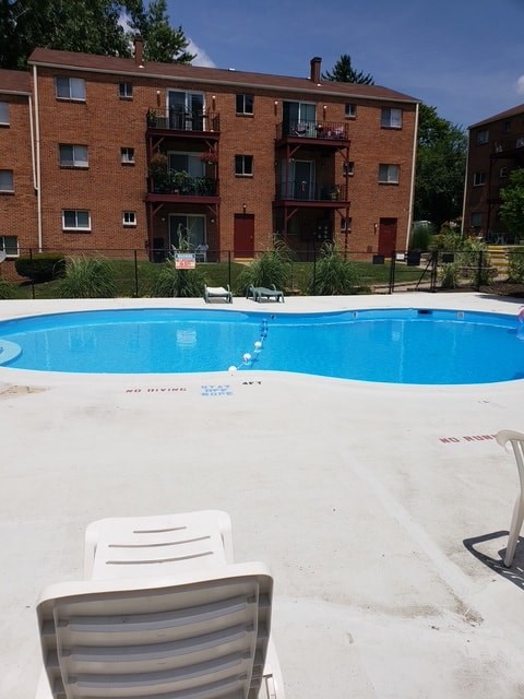 A chair is in the foreground of a swimming pool.