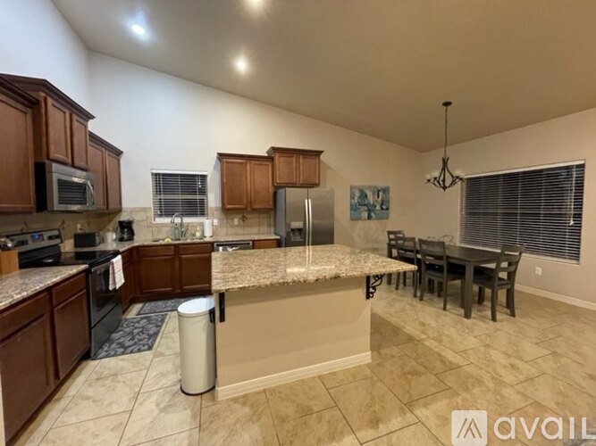 A kitchen with brown cabinets and a granite countertop.