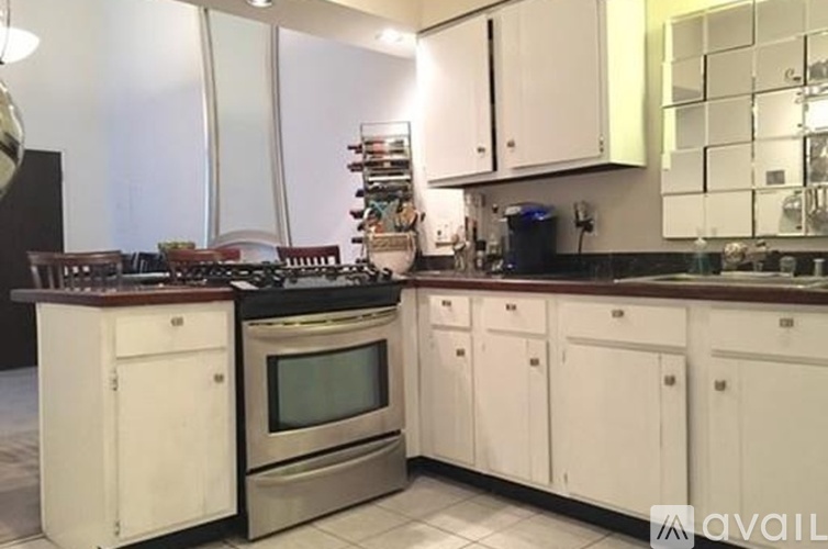 A kitchen with white cabinets and a stainless steel oven.
