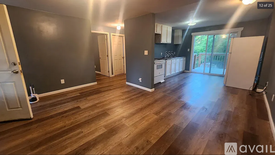 A room with wooden flooring and a white door.