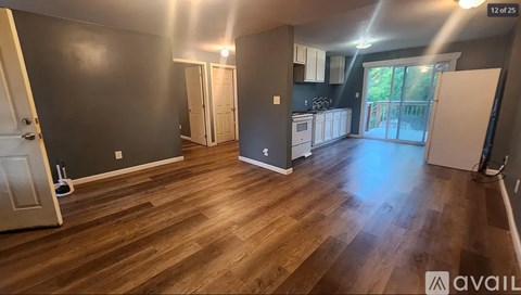 A room with wooden flooring and a white door.