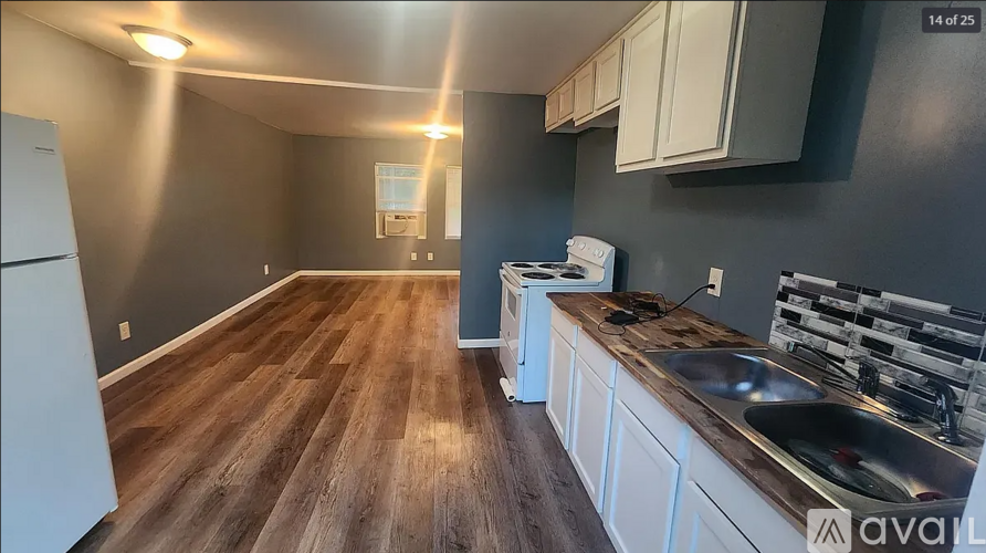 A kitchen with wooden floors and white appliances.
