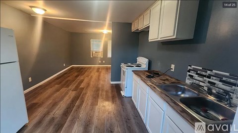 A kitchen with wooden floors and white appliances.