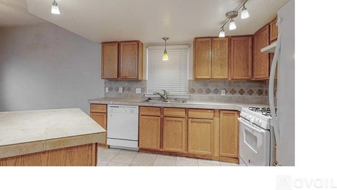 A kitchen with wooden cabinets and a white dishwasher.