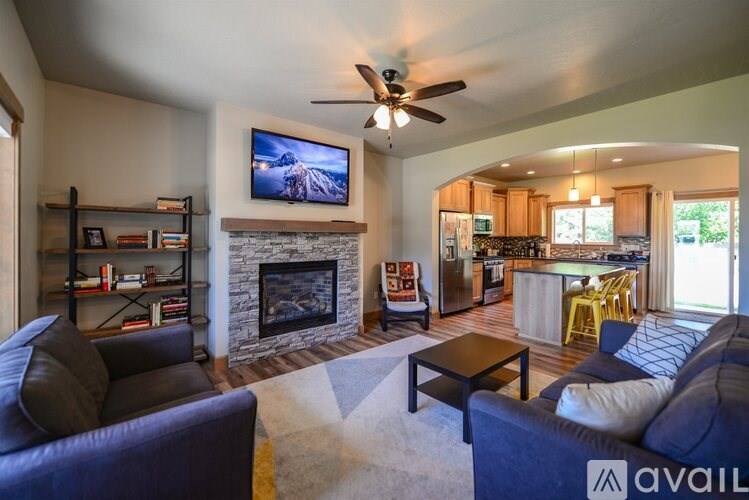A living room with a fireplace and a television on the wall.